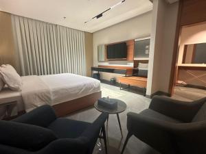 a hotel room with a bed and two chairs at فندق كلاودز Clouds Hotel in Al Madinah