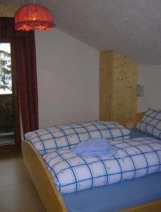 1 dormitorio con 1 cama con cuadros azules en Ferienwohnung Kirchbrücke, en Mieders