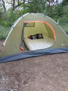 a green tent with two people sitting in it at Camping Mena’s in La Cruz