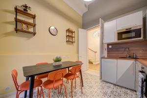 a kitchen with a table and some orange chairs at Casa Marie Unique Townhouse in Cospicua