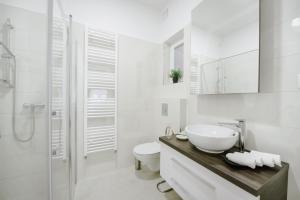 a white bathroom with a sink and a toilet at Apartment British Square with parking in Zagreb