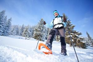 una mujer está parada en los esquís en la nieve en Chalet Silver Fox SPA at Fiddler's Lake en Mille-Isles