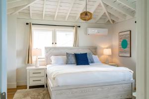 um quarto com uma cama branca e almofadas azuis em Blue Water View Condo in Prime Coastal Locale em San Diego