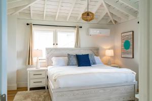 une chambre avec un lit blanc avec des oreillers bleus dans l'établissement Blue Water View Condo in Prime Coastal Locale, à San Diego