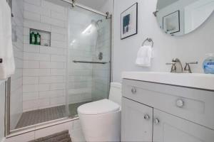 uma casa de banho branca com um WC e um chuveiro em Blue Water View Condo in Prime Coastal Locale em San Diego