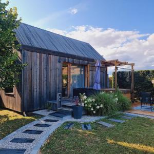 ein Holzhaus mit einer Terrasse und einem Sonnenschirm in der Unterkunft LE COTTAGE BARBIZONNAIS avec jacuzzi privé à partir de 10 ans in Barbizon