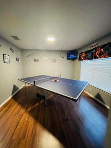 a ping pong table in a living room with at Lost Bluff Casa in San Antonio