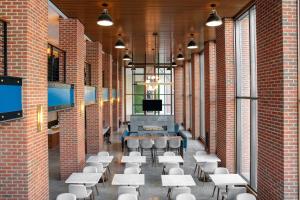 a room with tables and chairs in a brick building at Residence Inn by Marriott Norwalk in Norwalk