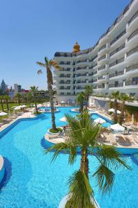 a large hotel with a large swimming pool with palm trees at Selectum For Two Side in Kizilagac