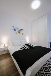 ein Schlafzimmer mit einem großen schwarzen und weißen Bett in der Unterkunft Apartment British Square with parking in Zagreb