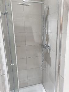 a shower with a glass door in a bathroom at Ensuite room in Thamesmead