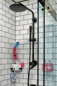 a shower with a red and white tile wall at Moxy Atlanta Midtown in Atlanta