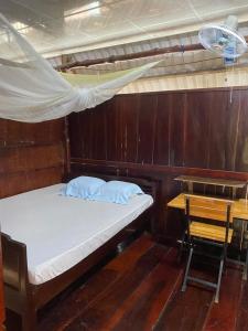 a bed in a wooden room with a desk and a bed sidx sidx sidx at Ba Hung homestay in Ấp Hòa Phú (2)