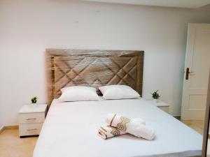 - une chambre avec un grand lit blanc et des serviettes dans l'établissement Appartement à MALABATA en face CENTRE COMMERCIAL MEGARAMA & la gare de TGV M2, à Tanger