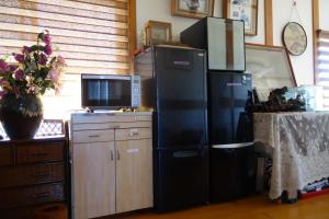a kitchen with a large black refrigerator and a tv at Natural Mind Tour guest house - Vacation STAY 23292v in Sado