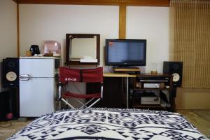 Schlafzimmer mit einem Schreibtisch, einem TV und einem Bett in der Unterkunft Natural Mind Tour - Vacation STAY 56703v in Sado