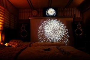 una pantalla de fuegos artificiales en una habitación con 2 camas en Natural Mind Tour guest house - Vacation STAY 22268v, en Sado