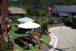einen Blick über einen Garten mit Sonnenschirm in der Unterkunft Natural Mind Tour guest house - Vacation STAY 22268v in Sado