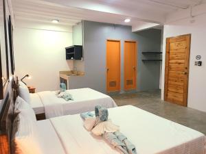 AV Suites في بويرتو غاليرا: غرفة فندقية بسريرين وغرفة بها