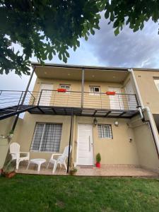 una casa con balcón y 2 sillas frente a ella en Departamentos Tomás Mason, en Santa Rosa