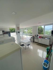 a kitchen and living room with a table and chairs at Hospedaria Trindade in Florianópolis
