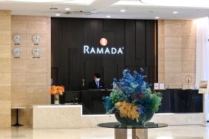a man in a suit sitting at a lobby at Ramada by Wyndham Yongin in Yongin