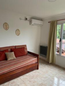 Una sala de estar con un sofá y una ventana. en Departamentos Tomás Mason, en Santa Rosa