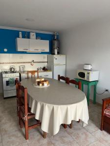 una cocina con una mesa y sillas y una mesa y una cocina con una mesa en Departamentos Tomás Mason, en Santa Rosa