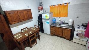 una pequeña cocina con mesa y nevera en Cabañas de Paola. en 