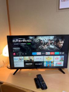 une télévision assise sur une table avec télécommande dans l'établissement Ocean Lovers Home, à Miyazaki