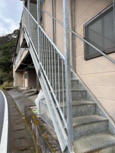 un conjunto de escaleras que conducen a un edificio en Ocean Lovers Home, en Miyazaki