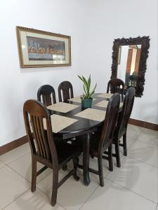 einen Esstisch mit Holzstühlen und einem Spiegel in der Unterkunft Casa Diversa in Esquipulas