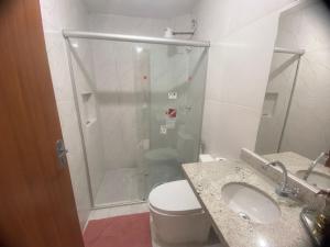 y baño con ducha, aseo y lavamanos. en Residencial pimenta - aluguel temporada - apto mobiliado en Cuiabá