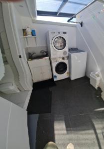 een wasmachine en een wasmachine in een kleine ruimte bij Bundeena Waterfront Pavilion in Bundeena