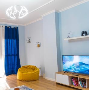 een woonkamer met blauwe muren en een tv bij Cane Apartment New Bazaar in Tirana