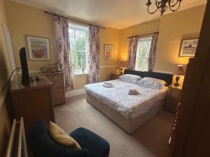 um quarto com uma cama e uma cadeira em The Postgate Inn em Egton