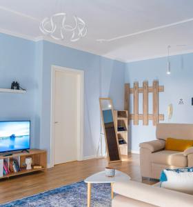 een woonkamer met een bank en een tv bij Cane Apartment New Bazaar in Tirana