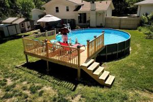 a pool with a ramp and people in a yard at Maple. Pleasant 4 bedroom house with pool in Omaha