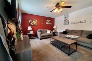 a living room with a couch and a table at Maple. Pleasant 4 bedroom house with pool in Omaha