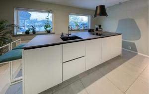 a kitchen with white cabinets and a sink at Nice Home In storp With Kitchen in Åstorp
