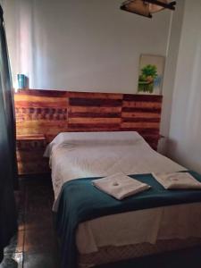 een slaapkamer met een bed met een handdoek erop bij Hostal La Palmera in Ezeiza
