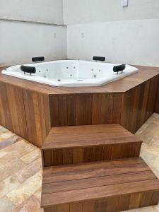a bath tub sitting on top of a wooden platform at Pousada Velas do Forte in Cabo Frio