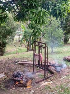 einen Grill mit einem Stuhl neben einem Feuer in der Unterkunft Chácara Goufran in Caçapava