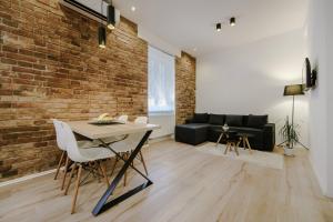 a living room with a brick wall and a table and chairs at Apartment British Square with parking in Zagreb