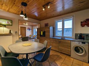 une cuisine et une salle à manger avec une table et des chaises dans l'établissement Gîte avec terrasse privative et jardin fleuri à Saugues, tout inclus - FR-1-582-90, à Saugues