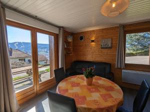 ein Esszimmer mit Tisch und Stühlen und einem Fenster in der Unterkunft Chalet familial avec cheminée à Gérardmer - FR-1-589-37 in Gérardmer