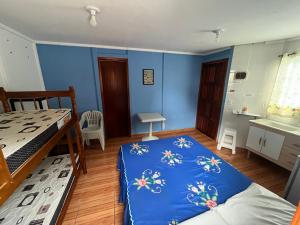 a bedroom with two beds and a blue wall at Chalé Master Caraguatatuba cond Alto Padrão Massaguaçu in Caraguatatuba