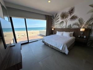 - une chambre avec un lit et une vue sur la plage dans l'établissement Soleare Hotel Boutique, à Tampico