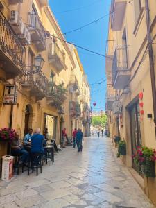 a group of people sitting at tables on a street at Salemi San Biagio townhouse in Sicily in Salemi