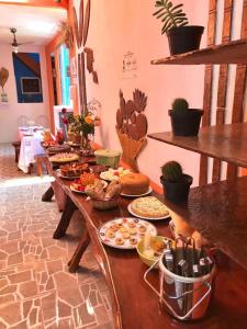a long wooden table with plates of food on it at Pousada Velho Garimpo in Lençóis